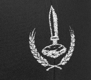 Man wearing a black cap with a logo and text, looking down on a white background